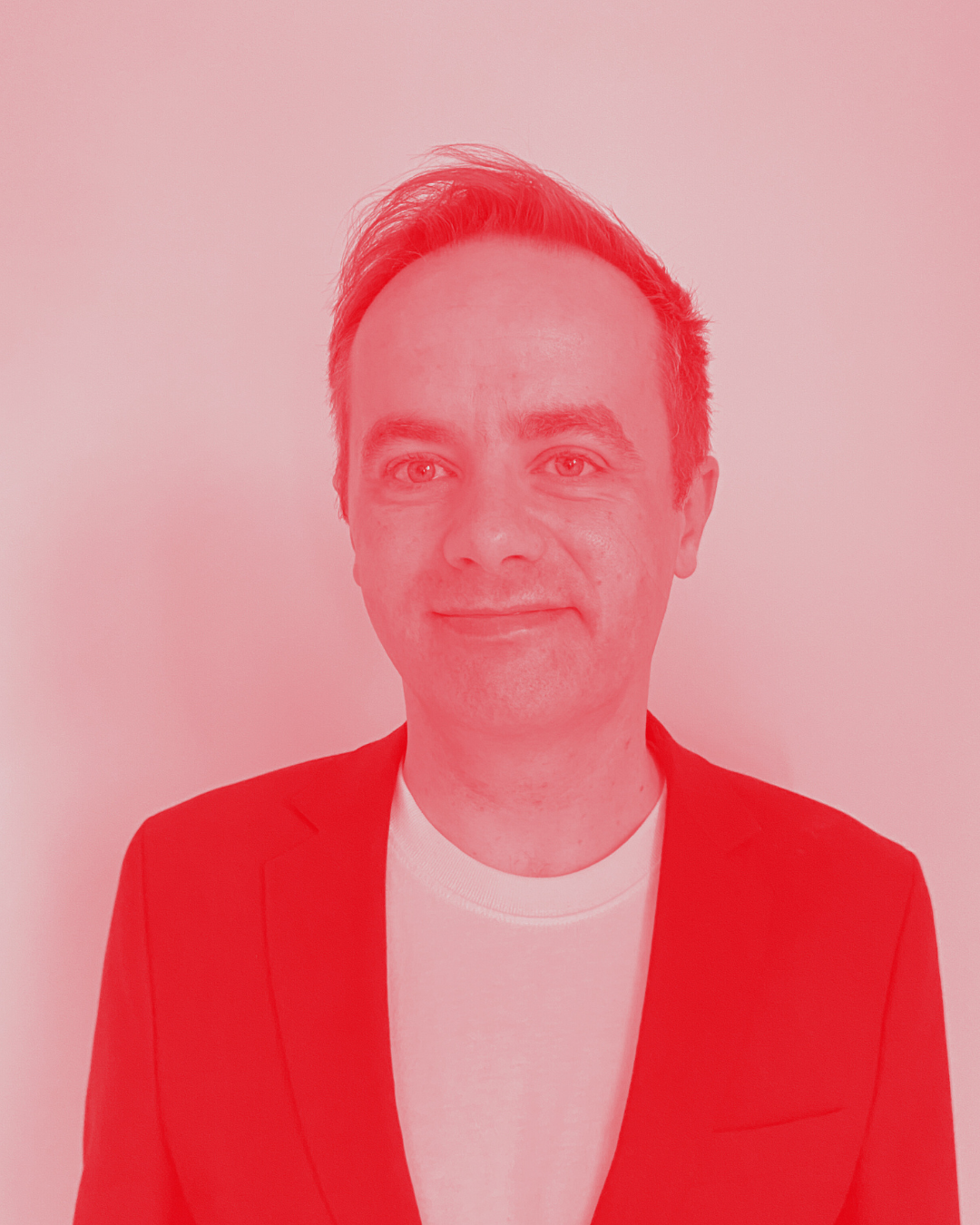 Das Bild zeigt den Autor des Textes, Timo Grunden. Er trägt ein weißes T-Shirt, schwarzes Jacket und lächelt in die Kamera.